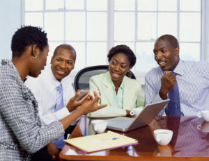 two businessmen and two businesswomen discussing in an office